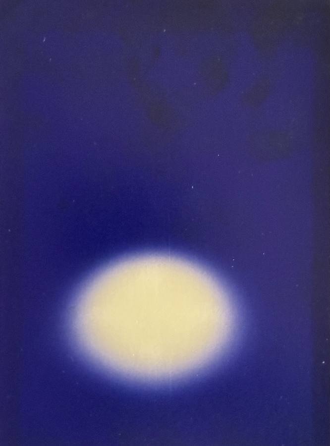 Pinhole photograph: a glowing pale oval low on a deep blue ground
