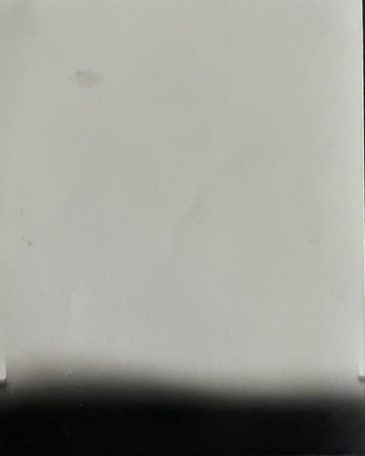 Pinhole photograph: a pale field with a dark band along the bottom edge