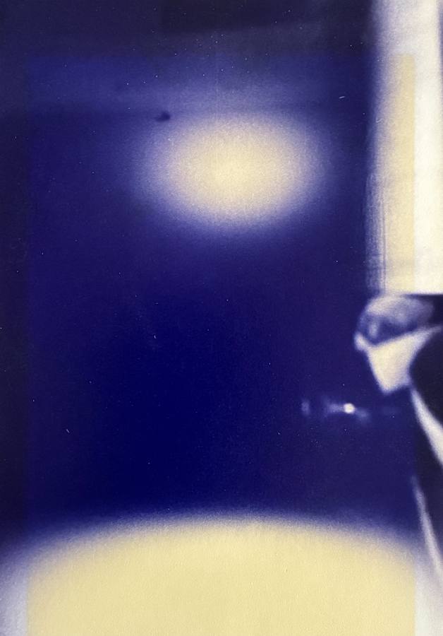 Pinhole photograph: a pale oval high on deep blue, with a light band at the foot