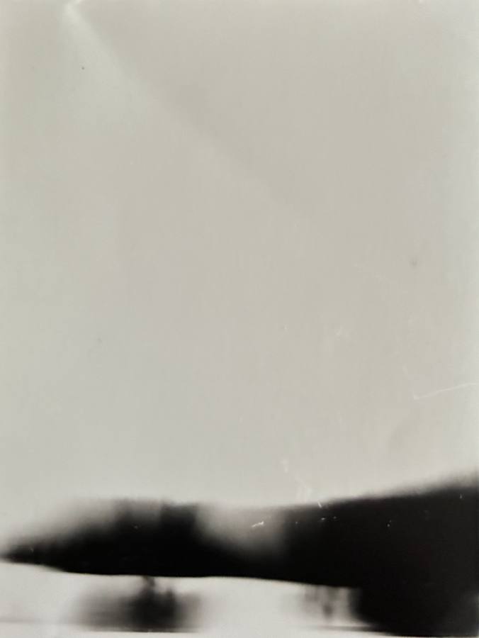 Pinhole photograph: a pale sky above a long dark blurred horizon