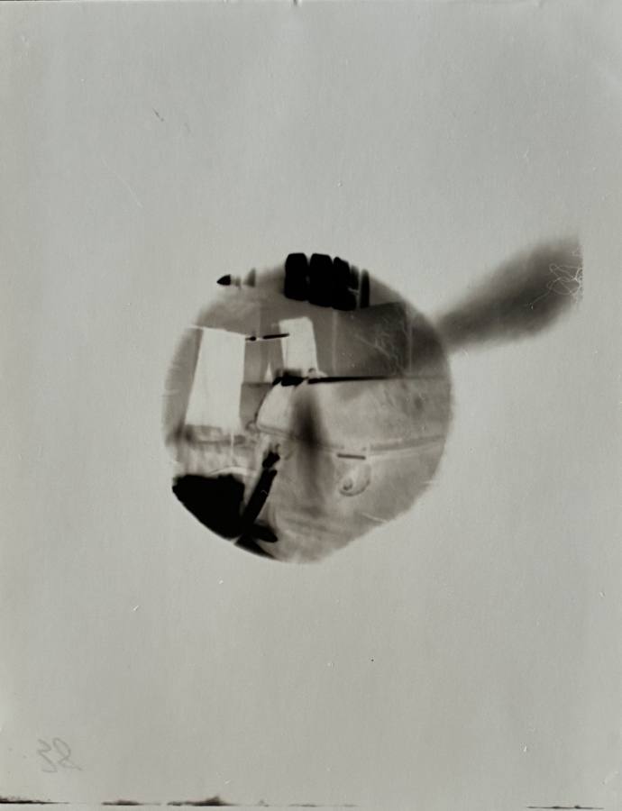 Pinhole photograph: a round view of a window frame with a dark plume to one side