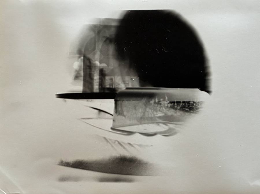 Pinhole photograph: an interior with a table edge and a dark arch, softly doubled